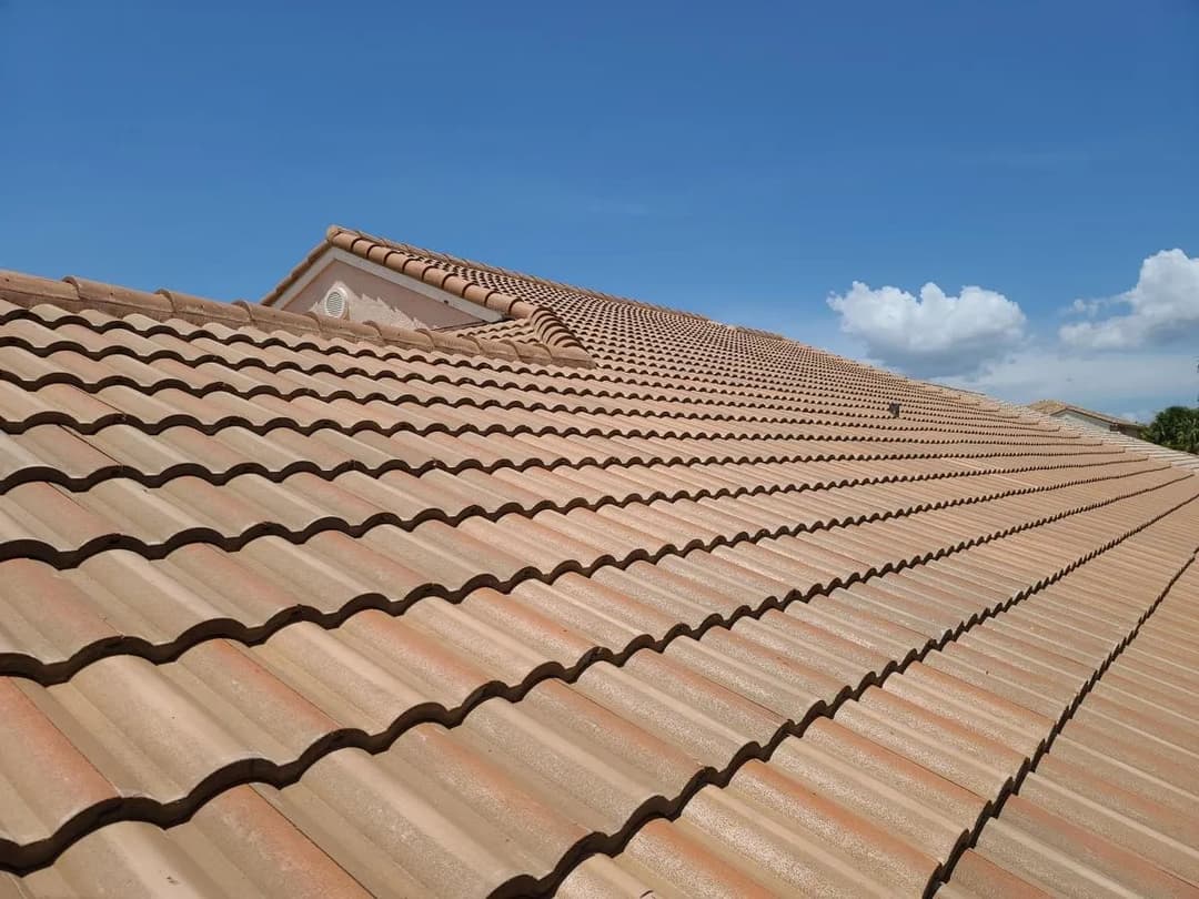 Terracotta tile roof against a clear blue sky, showcasing a well-maintained surface.