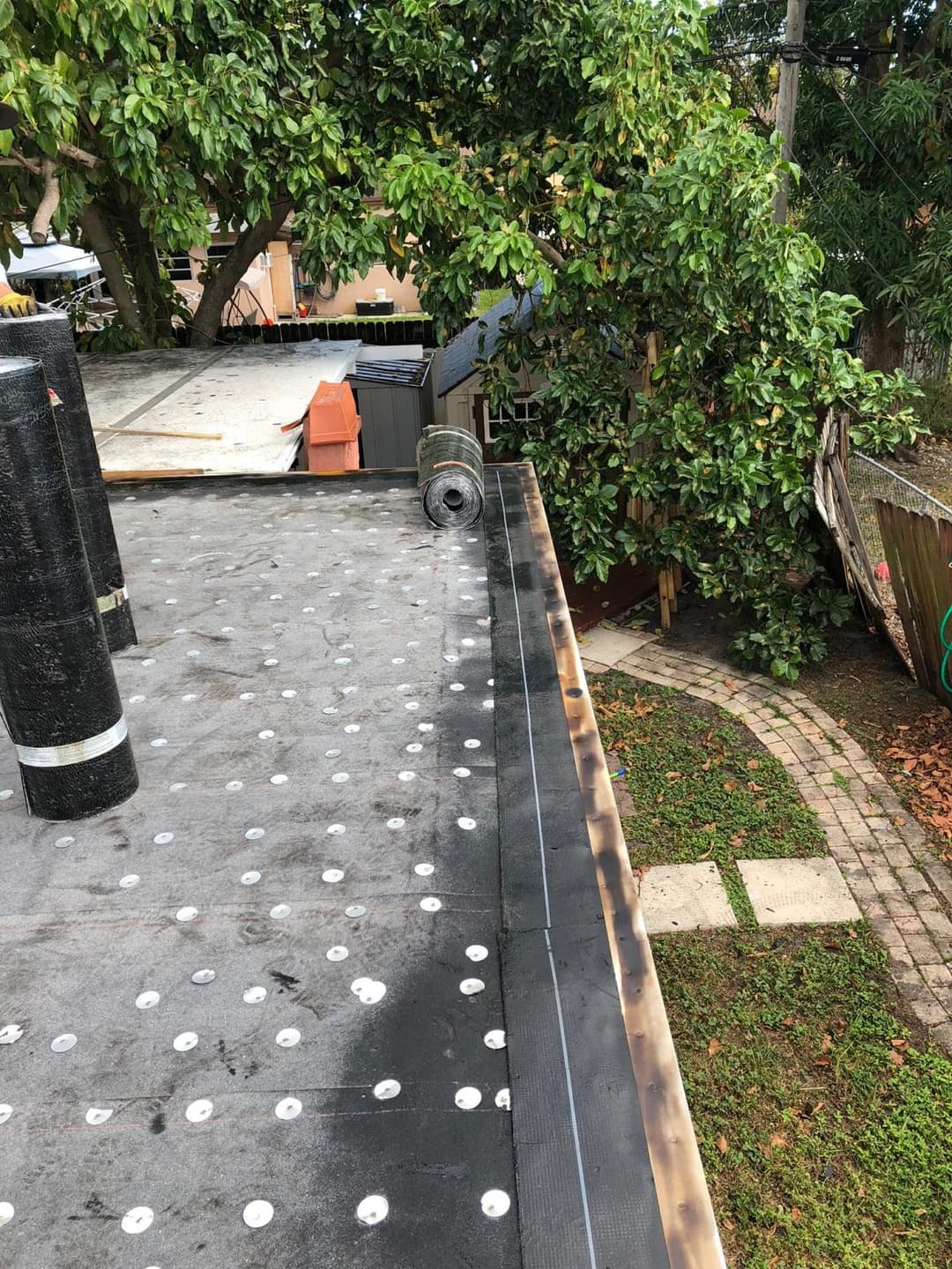 Roof installation in progress, showing materials and tools on a residential rooftop.